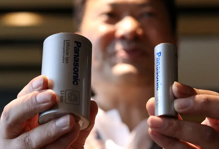 Kazuo Tadanobu, CEO da Panasonic's Energy Company mantém um protótipo da célula de bateria de formato 4680 (L) ao lado da bateria 2170 atual fornecida à Tesla Inc durante uma coletiva de imprensa em Tóquio, Japão (Tim Kelly/Reuters)