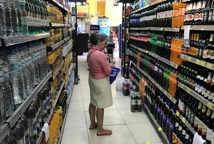Pessoa procura bebida em supermercado no Rio de Janeiro (Pilar Olivares/Reuters)