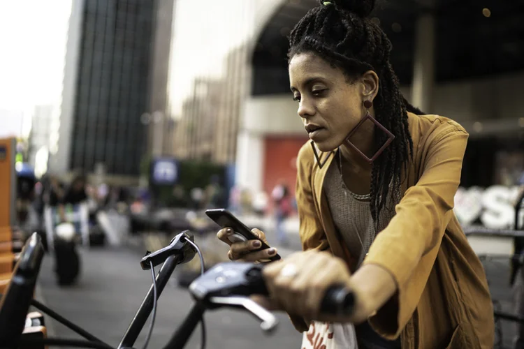 Mulher jovem alugando bicicleta compartilhada no centro de São Paulo (FG Trade/Getty Images)