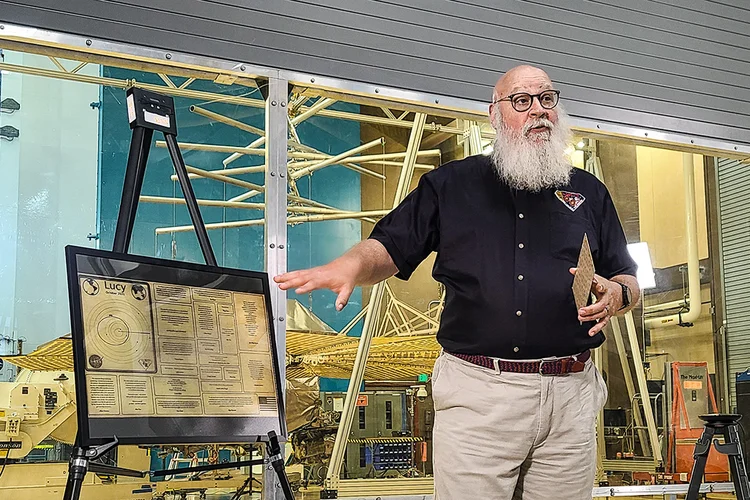 Colaborador da Nasa ao lado da placa Lucy (Nasa/Reprodução)