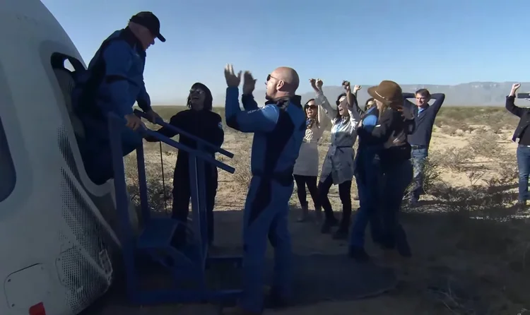 William Shatner sendo recebido por família, amigos e o CEO da Blue Origin, Jeff Bezos (Captura de tela/Exame)