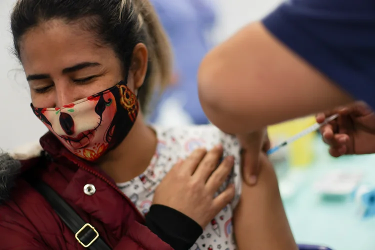 Mulher é vacinada. (Ivan Alvarado/Reuters)