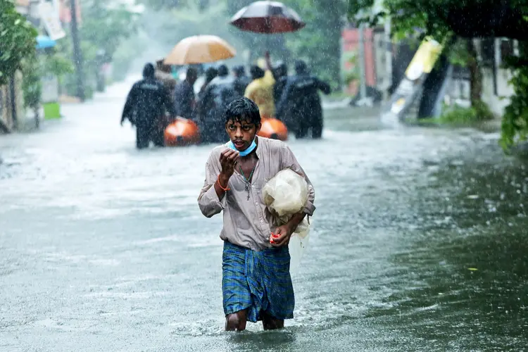 omem caminha em meio à inundação causada por fortes chuvas em Chennai, na Índia. (P. Ravikumar/Reuters)