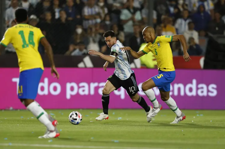 Lionel Messi é marcado por Edenilson durante partida entre Argentina e Brasil pelas eliminatórias para a Copa do Mundo. (Agustin Marcarian/Reuters)