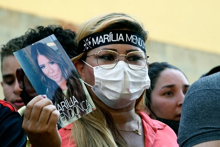 Fã de cantora brasileira Marília Mendonça segura uma foto da falecida artista, em frente ao centro esportivo Arena GoiâniaFã de cantora brasileira Marília Mendonça segura uma foto da falecida artista, em frente ao centro esportivo Arena Goiânia (EVARISTO/AFP via/Getty Images)