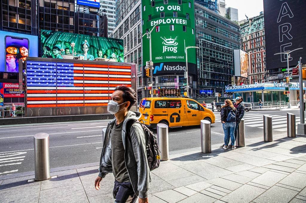 Pedestres usando máscaras de proteção passam pelo Nasdaq MarketSite em Nova York, EUA, na sexta-feira, 2 de outubro de 2020.  (Michael Nagle/Bloomberg)
