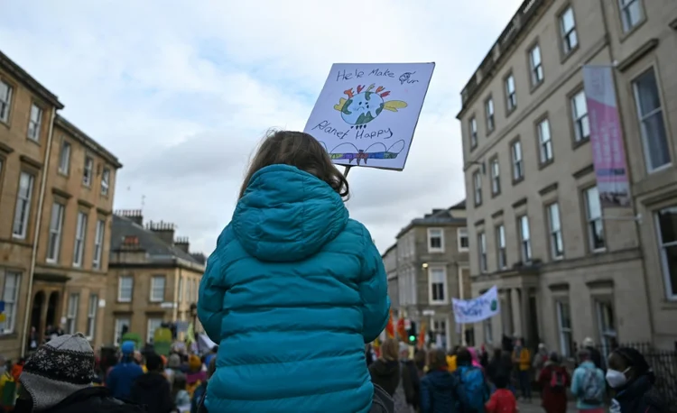 Uma jovem com cartaz durante marcha Fridays For Future em Glasgow. (STÉPHANE ORJOLLET/AFP)