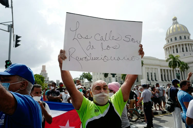 'As ruas pertencem aos revolucionários', diz cartaz de manifestante pró-governo, durante protesto contra o presidente cubano, Miguel Diaz-Canel, em Havana. (AFP/AFP)