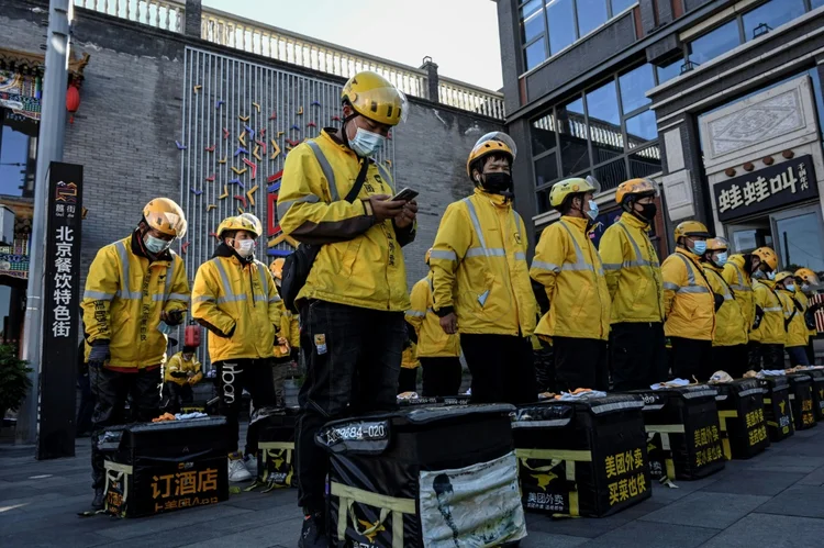 Todos os dias, na hora do almoço, um exército de entregadores roda pelas ruas do país para satisfazer o apetite de milhões de clientes (Beiyi SEOW, ZHANG Yuanhao/AFP)