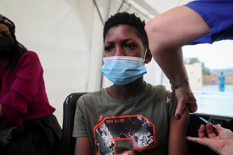 Profissional de saúde aplica vacina contra Covid-19 em adolescente em Johanesburgo, na África do Sul (Sumaya Hisham/Reuters)