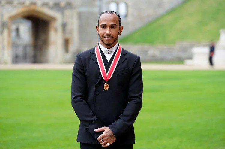 Heptacampeão mundial de Fórmula 1 Lewis Hamilton posa para foto após receber título de cavaleiro no Castelo de Windsor (Andrew Matthews/Pool/Reuters)