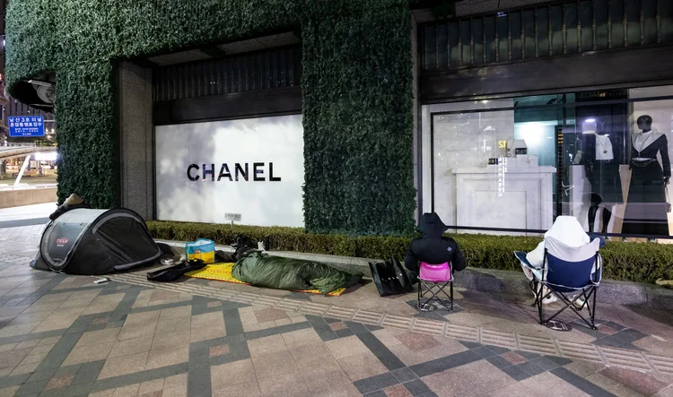 Consumidres esperam do lado de fora de uma loja da Chanel em Seul. (Bloomberg/Bloomberg)