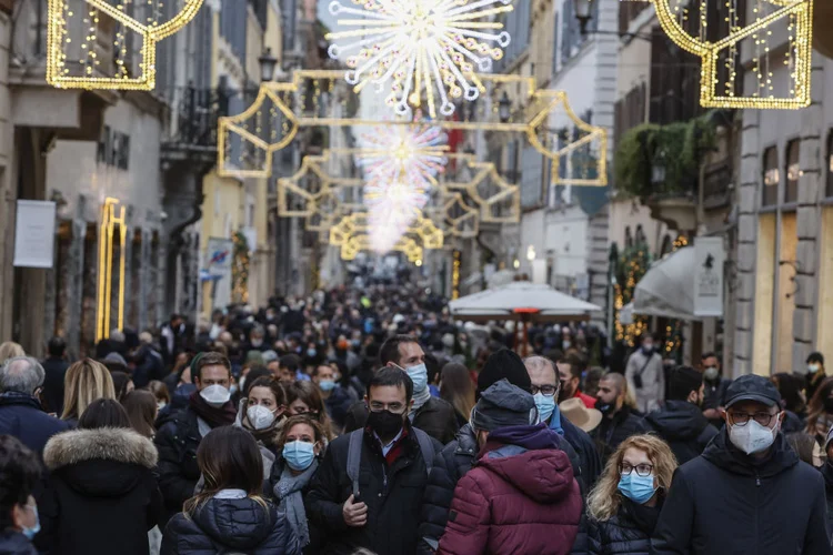 Pessoas caminham sob as luzes de Natal no centro de Roma, Itália, em 04 de dezembro de 2021 (Anadolu Agency / Colaborador/Getty Images)