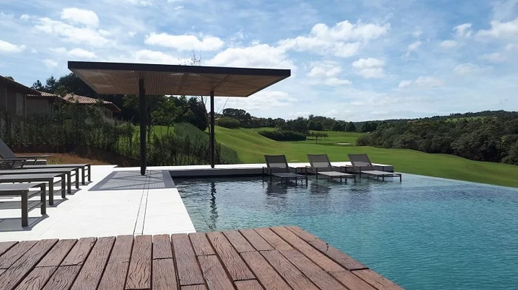 A piscina com borda infinita propõe que os moradores contemplem a paisagem, que parece completamente integrada, como se o mundo lá fora e o pátio da casa fossem uma coisa só. (Viva Decora/Divulgação)