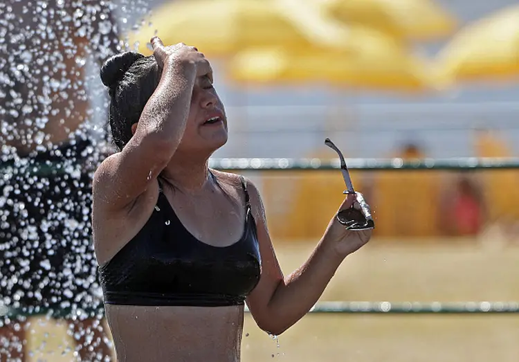 A woman cools off in a water game at the Parque de los Ninos (Children's Park), in Buenos Aires, on January 13, 2022, as an intense heat wave affects the metropolitan area of the Argentine capital and its surroundings. (Photo by Alejandro PAGNI / AFP) (Photo by ALEJANDRO PAGNI/AFP via Getty Images) (ALEJANDRO PAGNI/AFP via Getty Images/Getty Images)