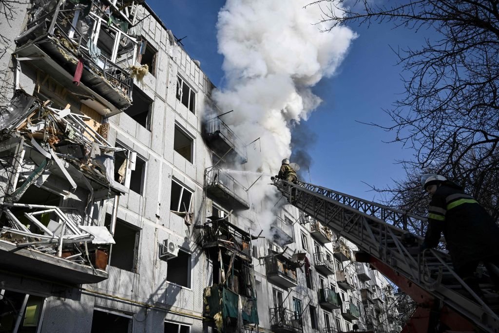 Bombeiros trabalham em um incêndio em um prédio após bombardeios na cidade de Chuguiv, no leste da Ucrânia, em 24 de fevereiro de 2022