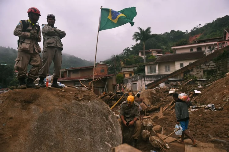 Bombeiros são vistos durante missão de resgate após deslizamento de terra gigante no bairro de Caxambu, em Petrópolis, Brasil, em 19 de fevereiro de 2022. (MAURO PIMENTEL/AFP)