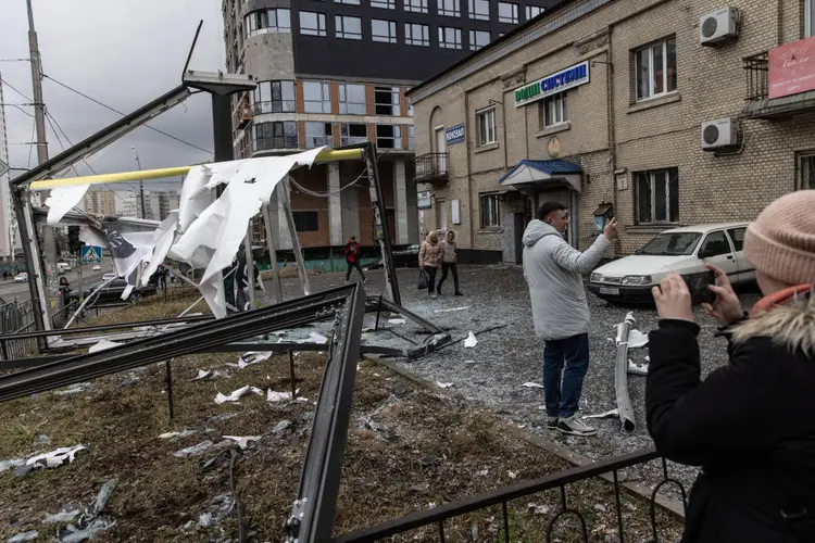 KYIV, UKRAINE - FEBRUARY 24: People take photos of damage caused by a rocket on February 24, 2022 in Kyiv, Ukraine. Overnight, Russia began a large-scale attack on Ukraine, with explosions reported in multiple cities and far outside the restive eastern regions held by Russian-backed rebels. (Photo by Chris McGrath/Getty Images) (Chris McGrath/Getty Images)