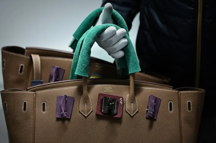 Um funcionário segurando bolsas na oficina de artigos de couro da fabricante francesa de artigos de luxo de alta moda Hermès. (AFP/AFP Photo)