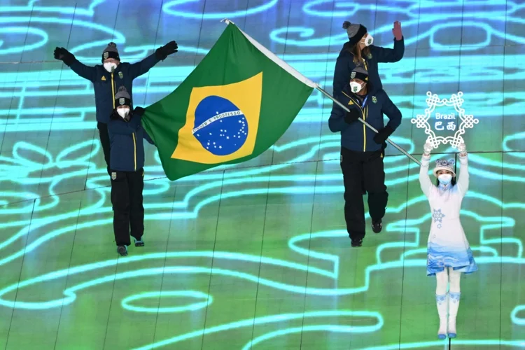 Jaqueline Mourão (E) e Edson Bindilatti, os porta-bandeiras do Brasil na cerimônia de abertura dos Jogos Olímpicos de Inverno de Pequim 2022. (PABLO SAN ROMAN/AFP)