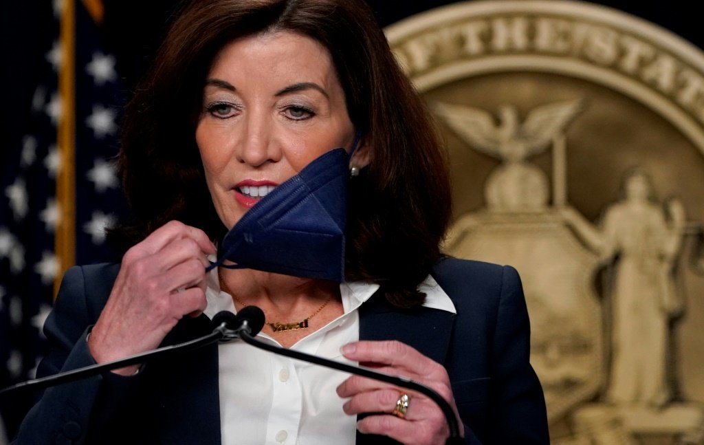 Governadora de Nova York, Kathy Hochul, retira máscara durante coletiva de imprensa sobre o fim da obrigatoriedade (AFP/AFP)