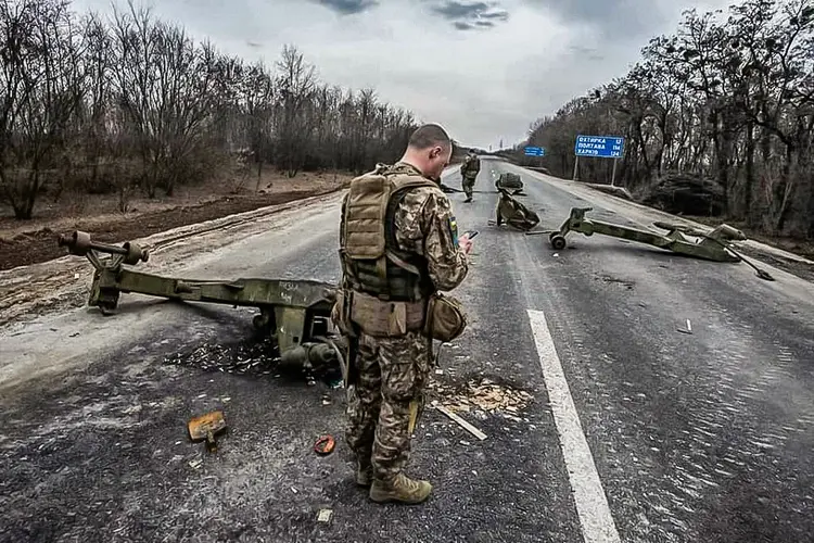 Soldados ucranianos caminhando entre equipamentos militares russos destruídos após uma batalha na cidade de Trostyanes, região de Sumy (Estado Maior das Forças Armadas da Ucrânia/AFP)