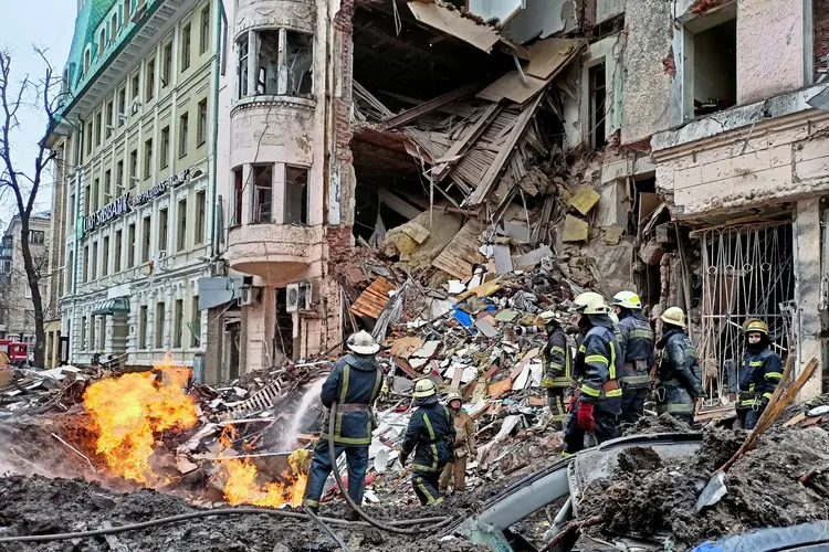 Equipes trabalham em prédio destruído em Kharkiv, na Ucrânia (Vitalii Hnidyi/Reuters)