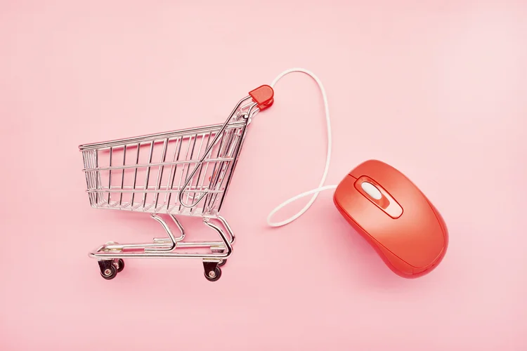 Still life of a small shopping cart and red computer mouse on pink background (Getty Images/Getty Images)