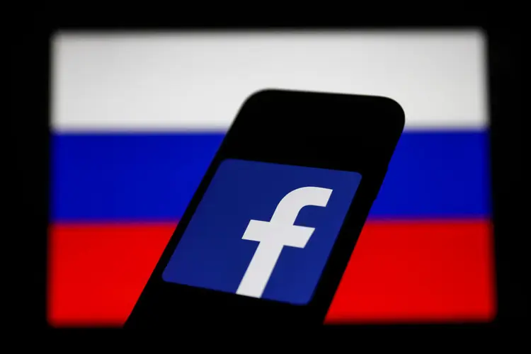 Facebook logo displayed on a phone screen and Russian flag displayed on a screen in the background are seen in this illustration photo taken in Krakow, Poland on March 1, 2022. (Photo Illustration by Jakub Porzycki/NurPhoto via Getty Images) (Jakub Porzycki/NurPhoto/Getty Images)