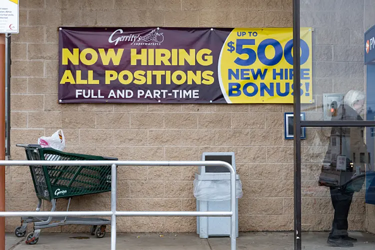 Anúncio de 'estamos contratando' em supermercado dos Estados Unidos: taxa de desemprego pode cair aos patamares pré-pandemia (Hannah Beier/Bloomberg via/Getty Images)