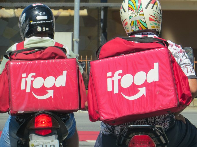 São Paulo, Brazil, April 28, 2020. Two motorcyclists, Ifood employees deliver food to customers in the city.