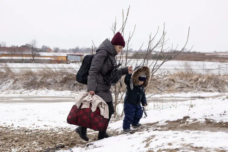 Mulher e criança em Krakovets, ba Ucrânia, rumo à Polônia: refugiados por ora são sobretudo mulheres e crianças (KRAKOVETS, UKRAINE - MARCH 09: Refugees fleeing conflict make their way to the Krakovets border crossing with Poland on March 09, 2022 in Krakovets, Ukraine. More than a million people have fled Ukraine following Russia's large-scale assault on the country, with hundreds of thousands of Ukrainians passing through Lviv on their way to Poland. (Photo by Dan Kitwood/Getty Images)/Getty Images)