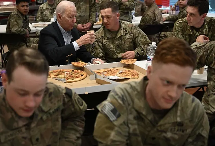 Joe Biden come pizza com soldados americanos na fronteira com a Ucrânia (Brendan SMIALOWSKI / AFP/Getty Images)