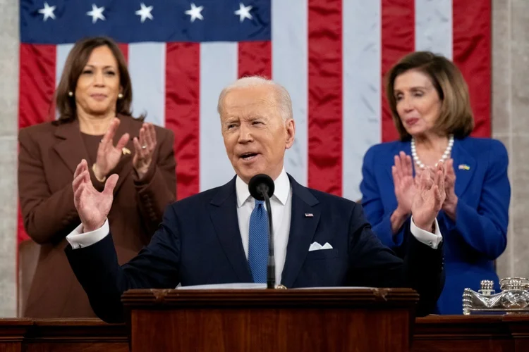 O presidente Joe Biden é aplaudido pela vice-presidente Harris (E) e a presidente do Congresso Nancy Pelosi durante o discurso sobre o Estado da União em 1 de março de 2022 no Congresso americano (AFP/AFP)
