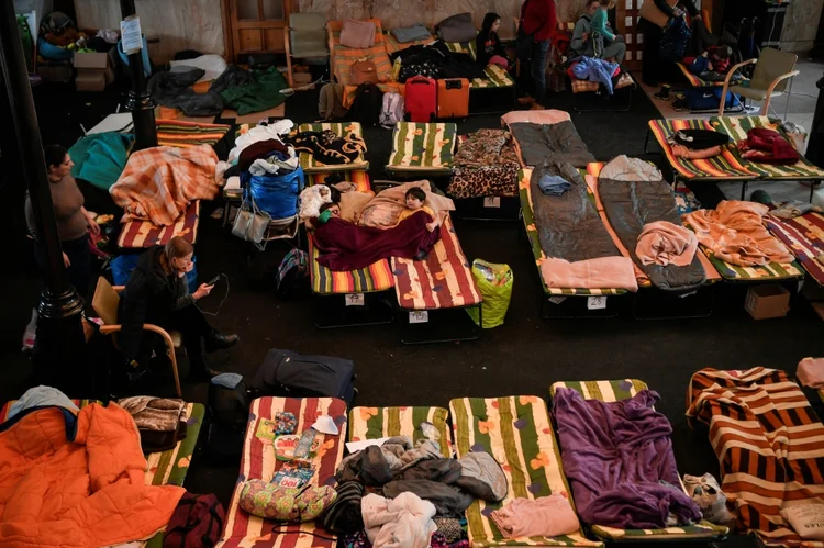 Refugiados da Ucrânia descansam em abrigo temporário na principal estação de trem de Cracóvia, Polônia. (AFP/AFP)