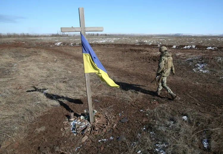 Soldado ucraniano junto a um memorial improvisado em Svetlodarsk, perto de Donetsk, na Ucrânia (AFP/AFP)