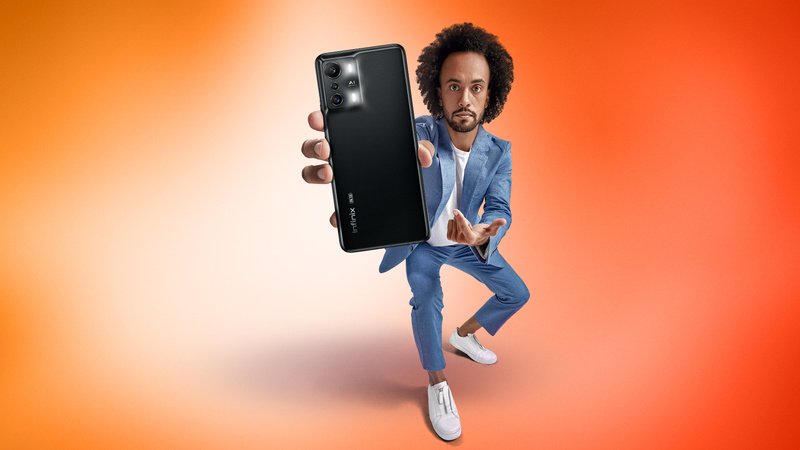 Homem negro segurando smartphone Infinix Zero 5G em fundo laranja