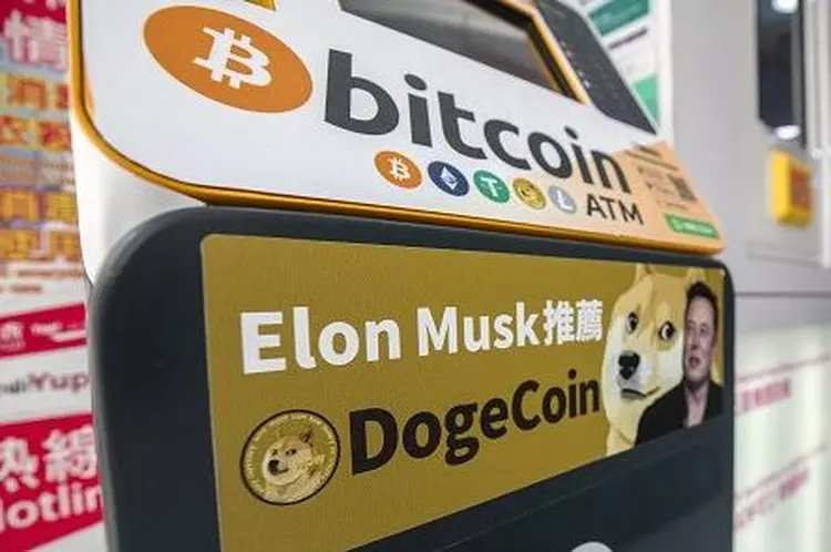 Propaganda com Elon Musk e símbolo da Dogecoin (Paul Yeung/Bloomberg/Getty Images)