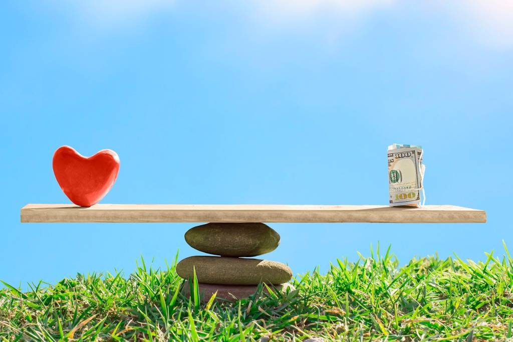 Dinheiro e coração em balança (FediushkinaElena/Getty Images)