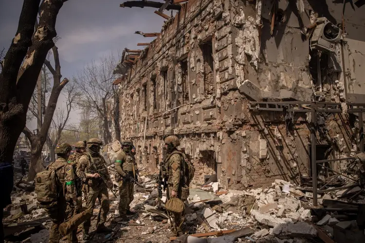 Kharkiv: soldados ucranianos caminham em meio a escombros depois que um shopping center foi atingido por um ataque de mísseis russos neste sábado, 16 (Chris McGrath/Getty Images)