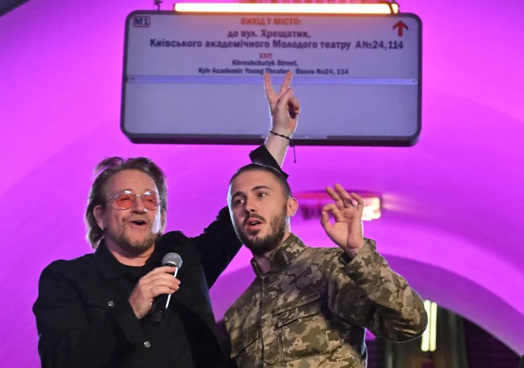 Bono, da banda de rock U2, e Antytila, líder de banda musical ucraniana e agora militar do exército ucraniano Taras Topolia, se apresentam na estação de metrô (Sergei SUPINSKY/AFP)