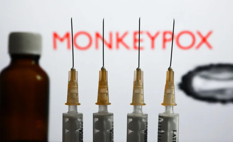 Medical syringes and a bottle are seen with 'Monkeypox' sign and monkeypox illustrative model displayed on a screen in the background in this illustration photo taken in Krakow, Poland on May 26, 2022. (Photo by Jakub Porzycki/NurPhoto via Getty Images) (Divulgação/Divulgação)