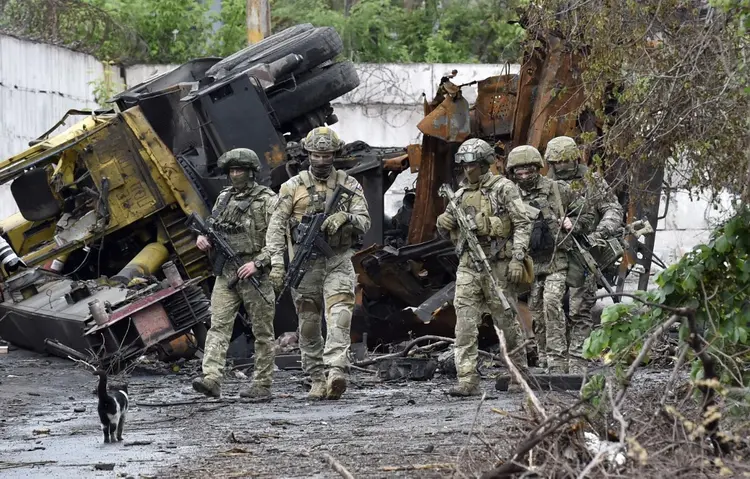 Militares russos patrulham a parte destruída da Ilyich Iron and Steel Works na cidade portuária de Mariupol, na Ucrânia, em 18 de maio de 2022, em meio à ação militar russa em andamento na Ucrânia. (Olga MALTSEVA/AFP)