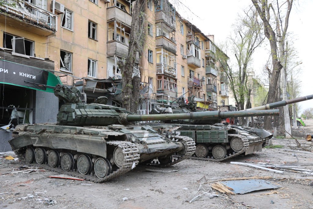 Tanques são vistos em frente ao prédio danificado enquanto os ataques russos continuam em Mariupol, Ucrânia, em 04 de maio de 2022. (Getty Images/Leon Klein/Anadolu Agency)