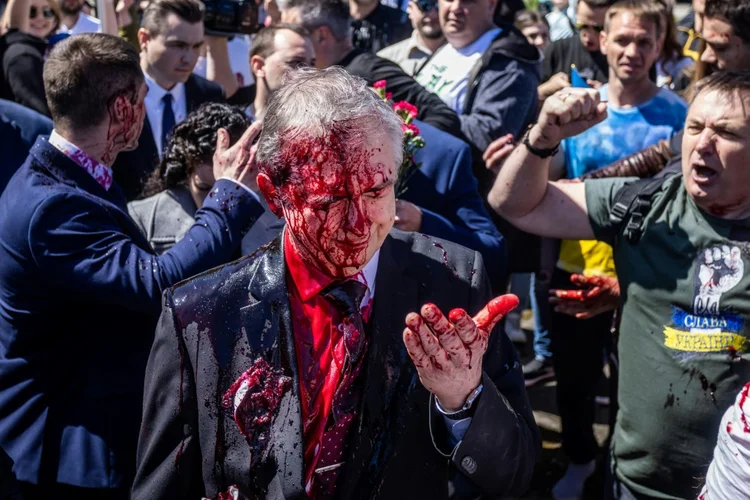 Embaixador russo na Polônia, Sergey Andreev, após ser coberto com tinta vermelha durante um protesto em Varsóvia, na Polônia, em 9 de maio de 2022 (AFP/AFP)