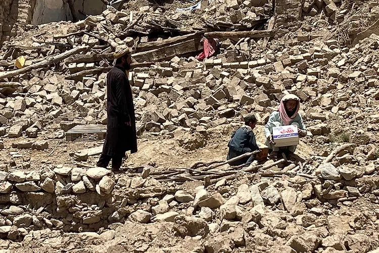 Men stand amid the rubble of damaged houses following an earthquake in Bermal district, in Paktika province on June 23, 2022. - Desperate rescuers battled against the clock and heavy rain on June 23 to reach cut-off areas in eastern Afghanistan after a powerful earthquake killed at least 1,000 people and left thousands more homeless. (Photo by Emmanuel PEUCHOT / AFP) (Photo by EMMANUEL PEUCHOT/AFP via Getty Images) (EMMANUEL PEUCHOT/Getty Images)