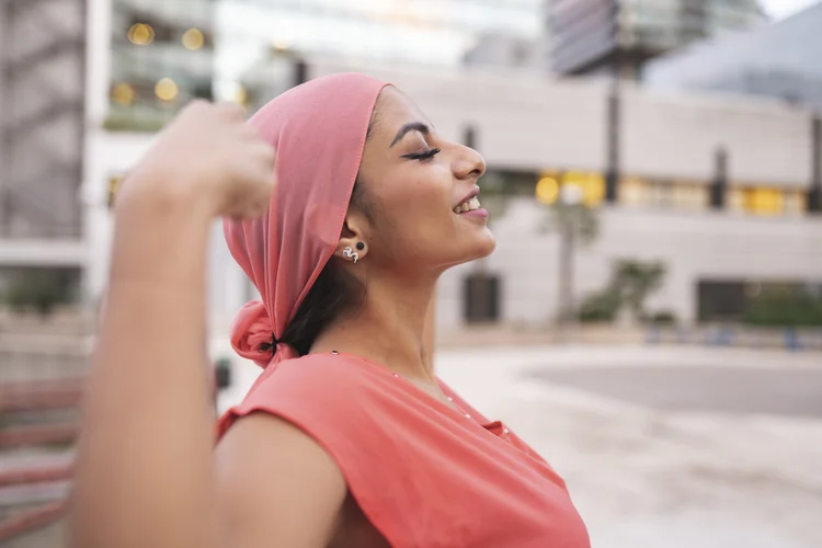 pretty with pink cancer scarf woman with raised arms showing muscle (jose carlos cerdeno martinez/Getty Images)