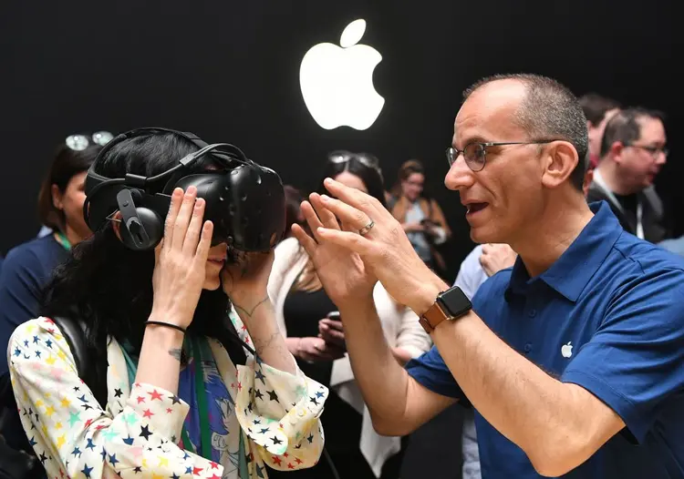 Ainda não é o óculos da Apple: funcionário da empresa ajuda uma repórter a experimentar um dispositivo da HTC Vive, conectado a um iMac, durante a Conferência Mundial de Desenvolvedores da Apple, em 2017. (JOSH EDELSON/Getty Images)