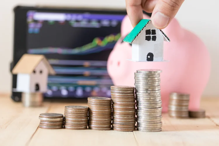 Mortgage investment and saving for real estate concept, stack of coins and house made from paper cardboard (Getty/Getty Images)