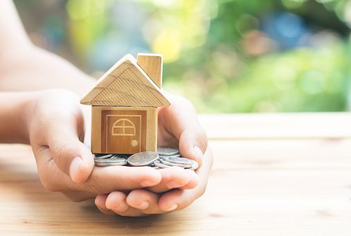 Coins and Home Model are placed on the hands is planning savings money of coins to buy a home concept concept for property ladder, mortgage and real estate investment. for saving or investment (Getty Images/Getty Images)